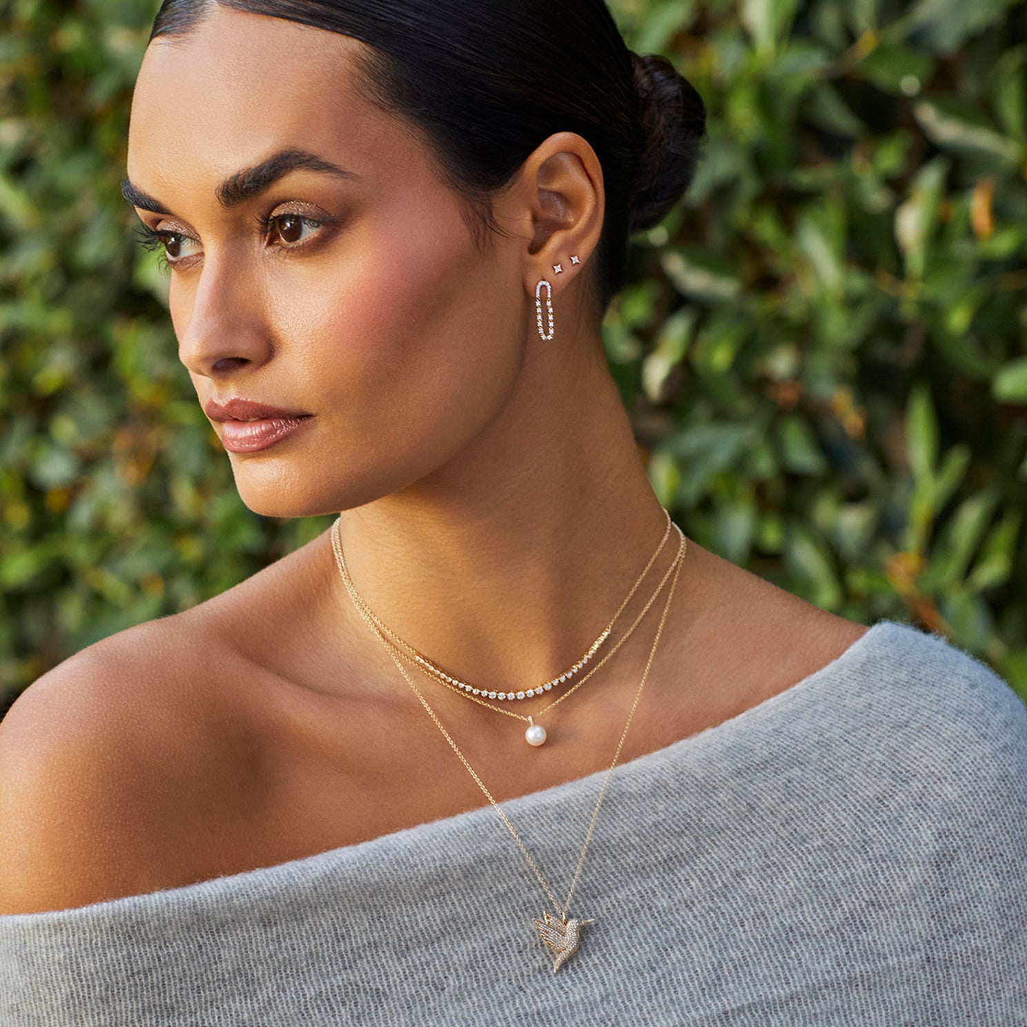Pearl Ball Drop Necklace in 14k yellow gold styled on neck of model with diamond and hummingbird necklaces