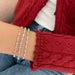 Diamond Multifaceted Eternity Bracelet in 14k yellow, rose, and white gold styled on wrist of model wearing red sweater