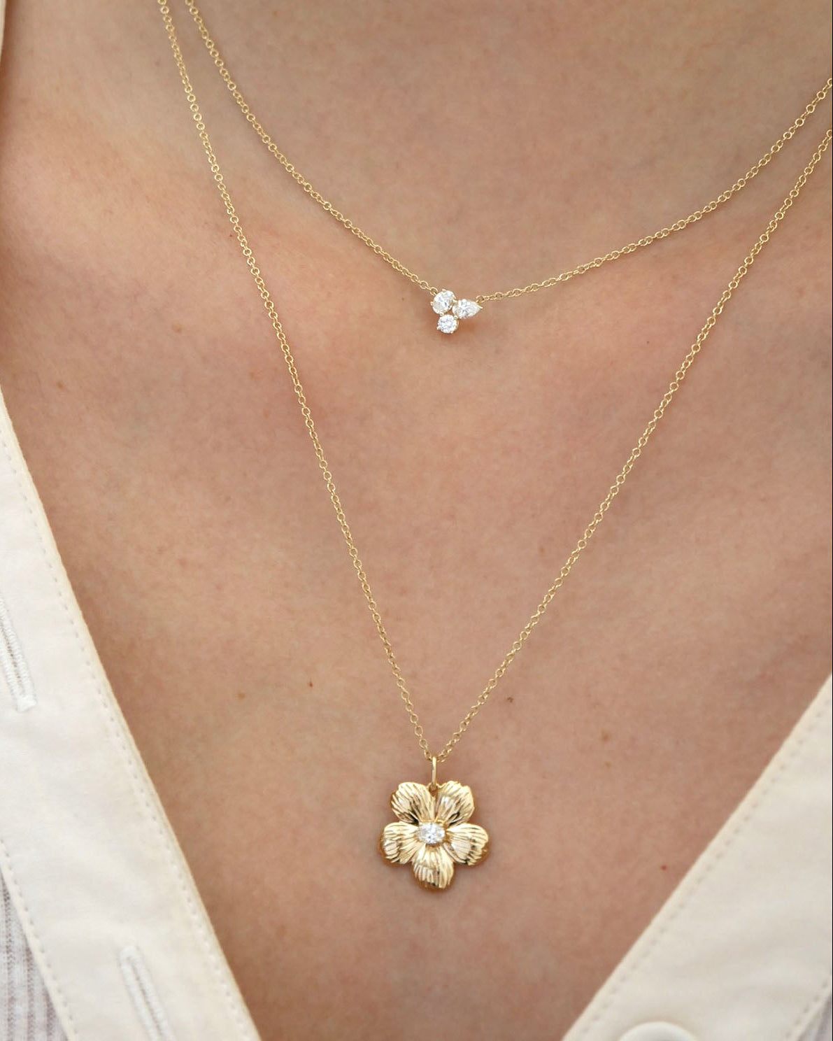 Cherry Blossom Necklace in 14k yellow gold styled on neck with diamond necklace