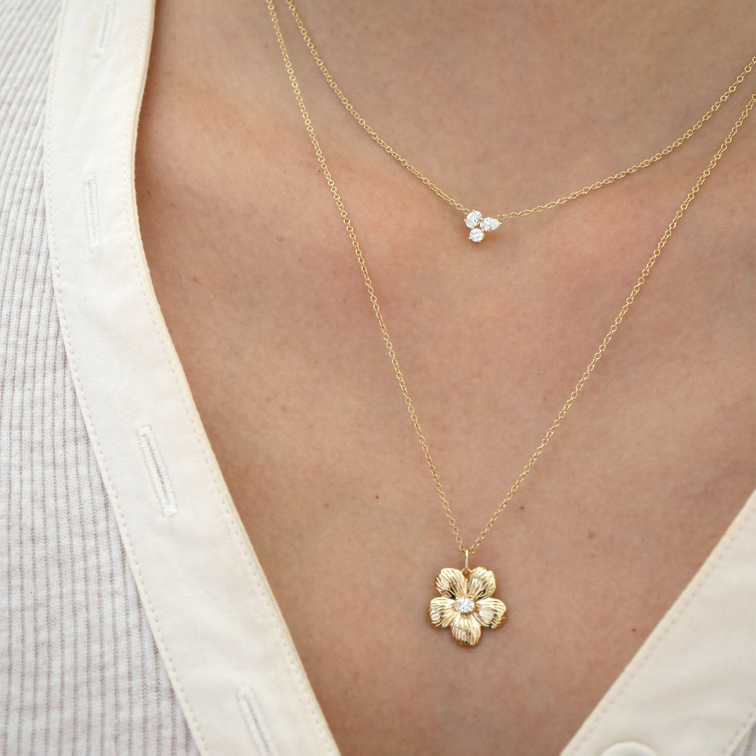 Cherry Blossom Necklace in 14k yellow gold styled on neck with diamond necklace