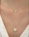 Cherry Blossom Necklace in 14k yellow gold styled on neck with diamond necklace