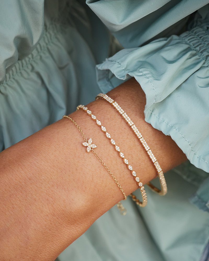 EF Collection 14k yellow gold bracelets with diamonds styled on wrist of model in teal blouse