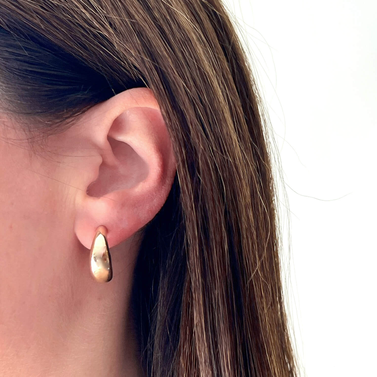 Gold Jumbo Dome Hoop Earrings in 14k yellow gold styled on ear of model