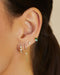 Pillow Chain Diamond Mini Huggie Earring in 14k yellow gold styled on second earring hole of model next to three earrings