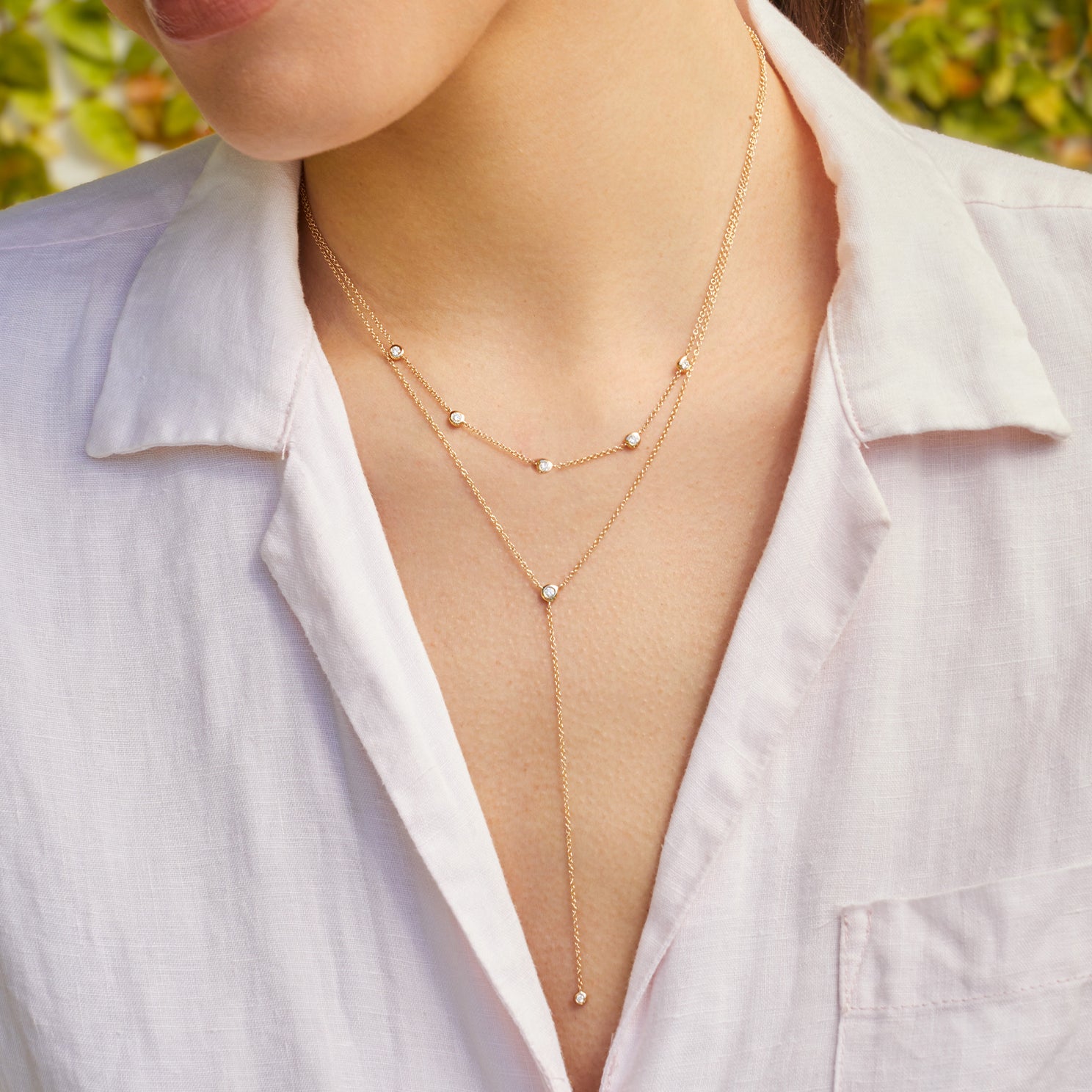 Diamond Pillow Lariat Necklace in 14k yellow gold styled on neck of model with layered necklace