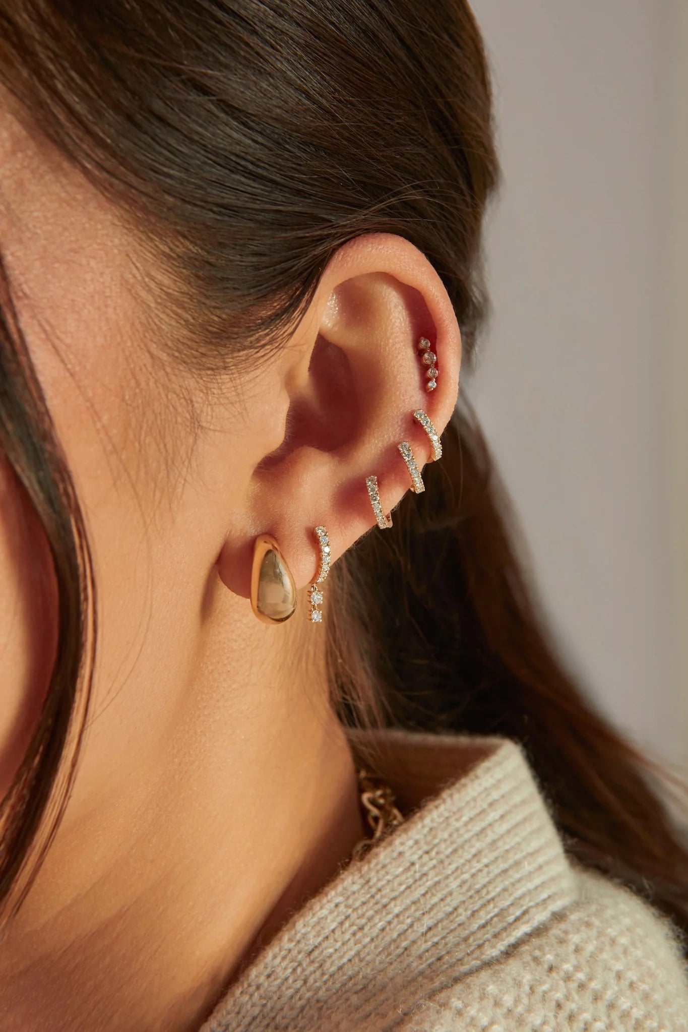 EF Collection 14k yellow gold earrings with diamonds styled on ear lobe of model