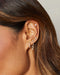 Diamond Crown Huggie Earring styled on ear of model with diamond earrings