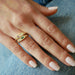 Diamond & Emerald Treasure Ring styled on ring finger of model with gold, diamond, and pink sapphire ring