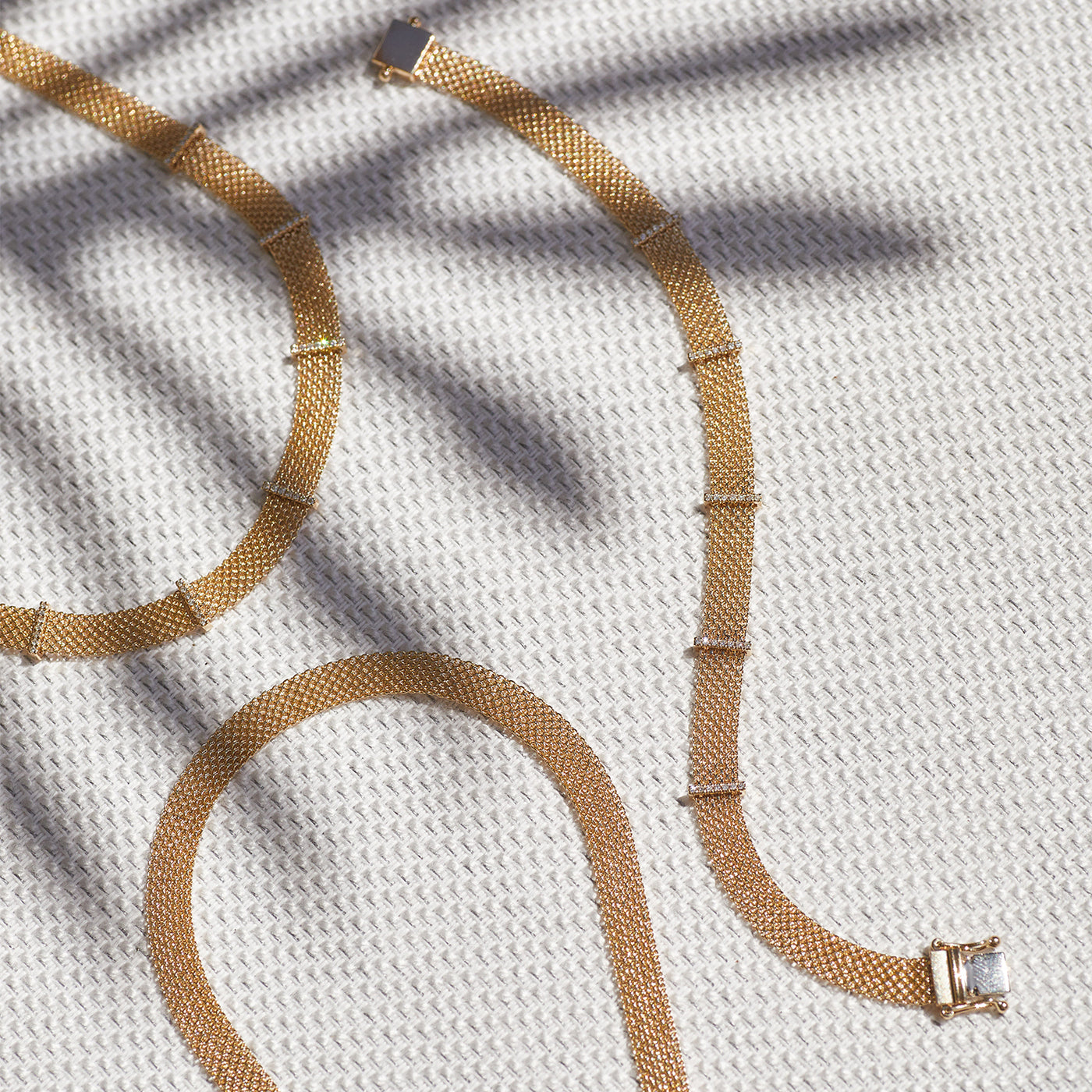Gold Mesh Necklace in 14k yellow gold next to diamond bar necklace and diamond bar bracelet with palm tree shadow