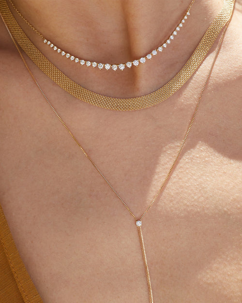 Gold Mesh Necklace in 14k yellow gold styled on neck of model with graduated diamond necklace and diamond lariat necklace