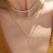 Gold Mesh Necklace in 14k yellow gold styled on neck of model with graduated diamond necklace and diamond lariat necklace