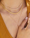 Gold Mesh Necklace in 14k yellow gold styled with a diamond necklace and lariat necklace on a model wearing mustard yellow top