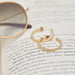 Gold Fluted Hoop Earrings in 14k yellow gold next to lens of sunglass on top of book 