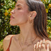 Emerald Wild Palm Stud Earring in 14k yellow gold styled on ear of model with multiple earrings