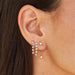 Suspended Diamond Stud Earring in 14k yellow gold on first earring hole next to multi diamond chain stud earrings on ear of model