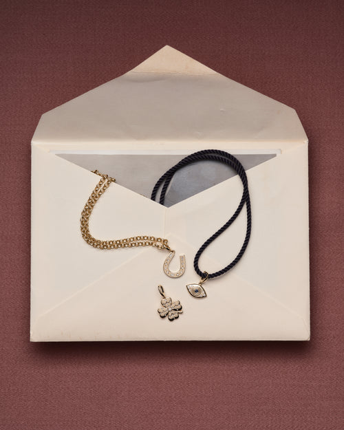 Diamond Horseshoe Clip Charm, Diamond Clover Charm, Evil Eye Charm on white envelope
