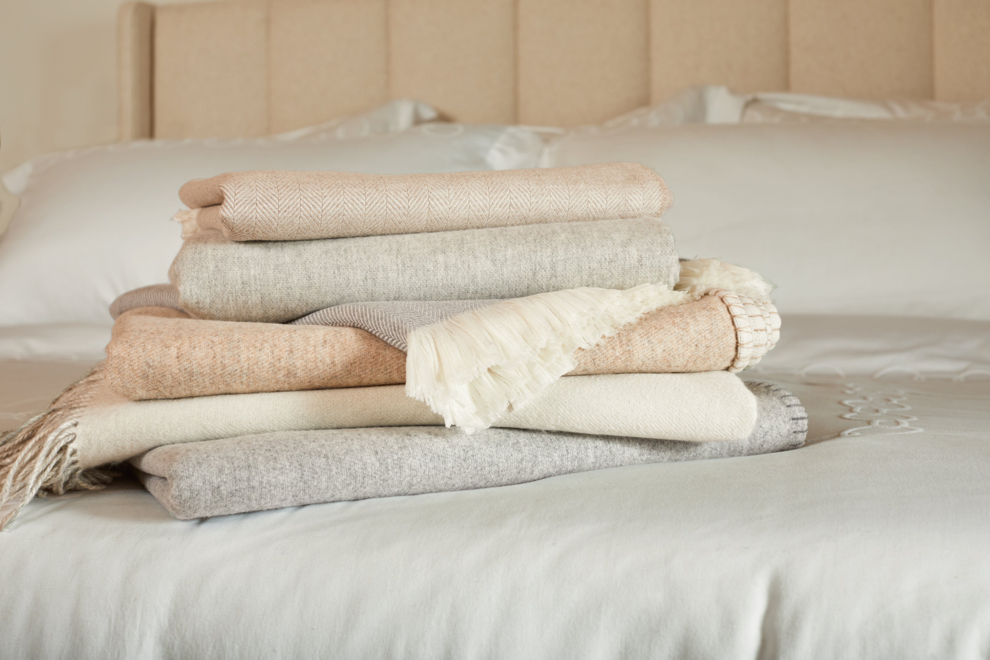 EF Home Blankets Displayed Stacked on Bed