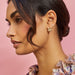 Diamond Oval Stud Earring styled on ear lobe of model with cherry blossom earring
