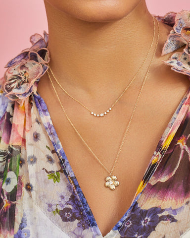 Cherry Blossom Necklace in 14k yellow gold styled on neck of model in floral blouse