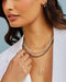 Floating Evil Eye Necklace in 14k yellow gold styled on neck of model with diamond and birthstone bead necklaces