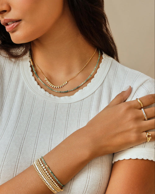 Ombré Tourmaline Birthstone Bead Necklace in 14k yellow gold styled on neck of model with gold and diamond necklace on model in white tshirt