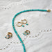 Seaside Stone Mini Huggie Earring in 14k yellow gold next to gold and turquoise earrings and necklaces