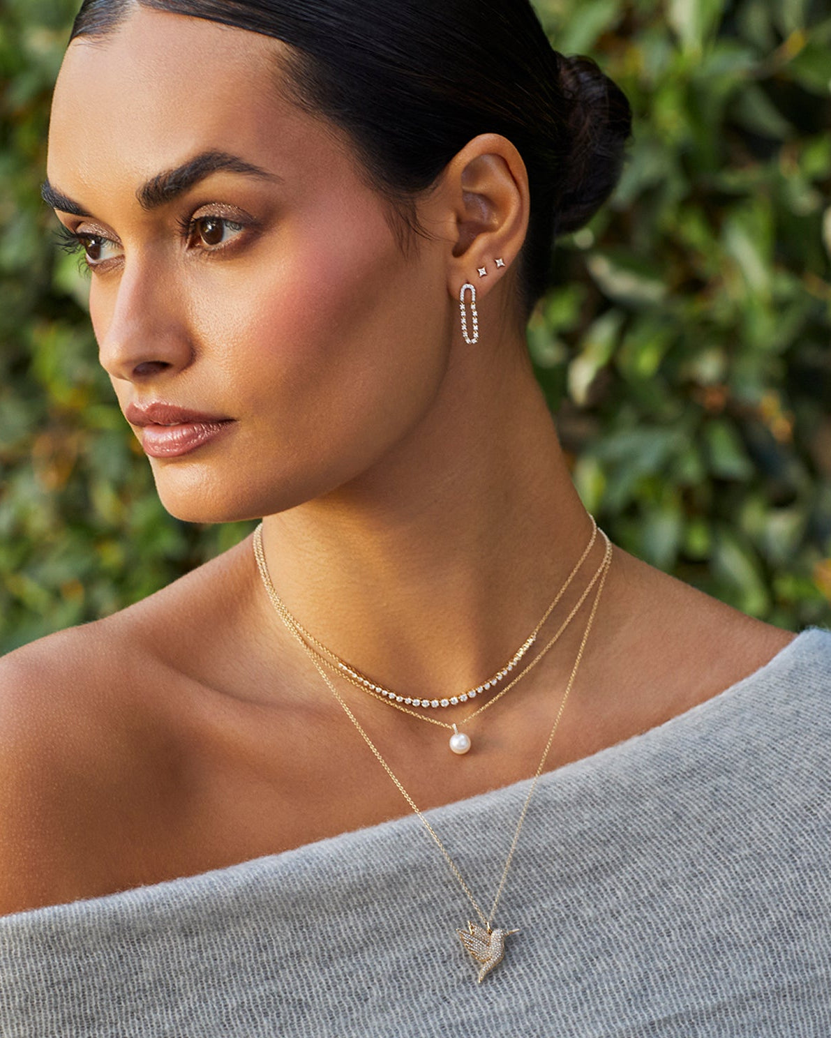 Pearl Ball Drop Necklace in 14k yellow gold styled on neck of model with diamond and hummingbird necklaces