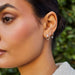 The Iris Illusion Stud Earrings in 14k yellow gold styled on first earring hole of model