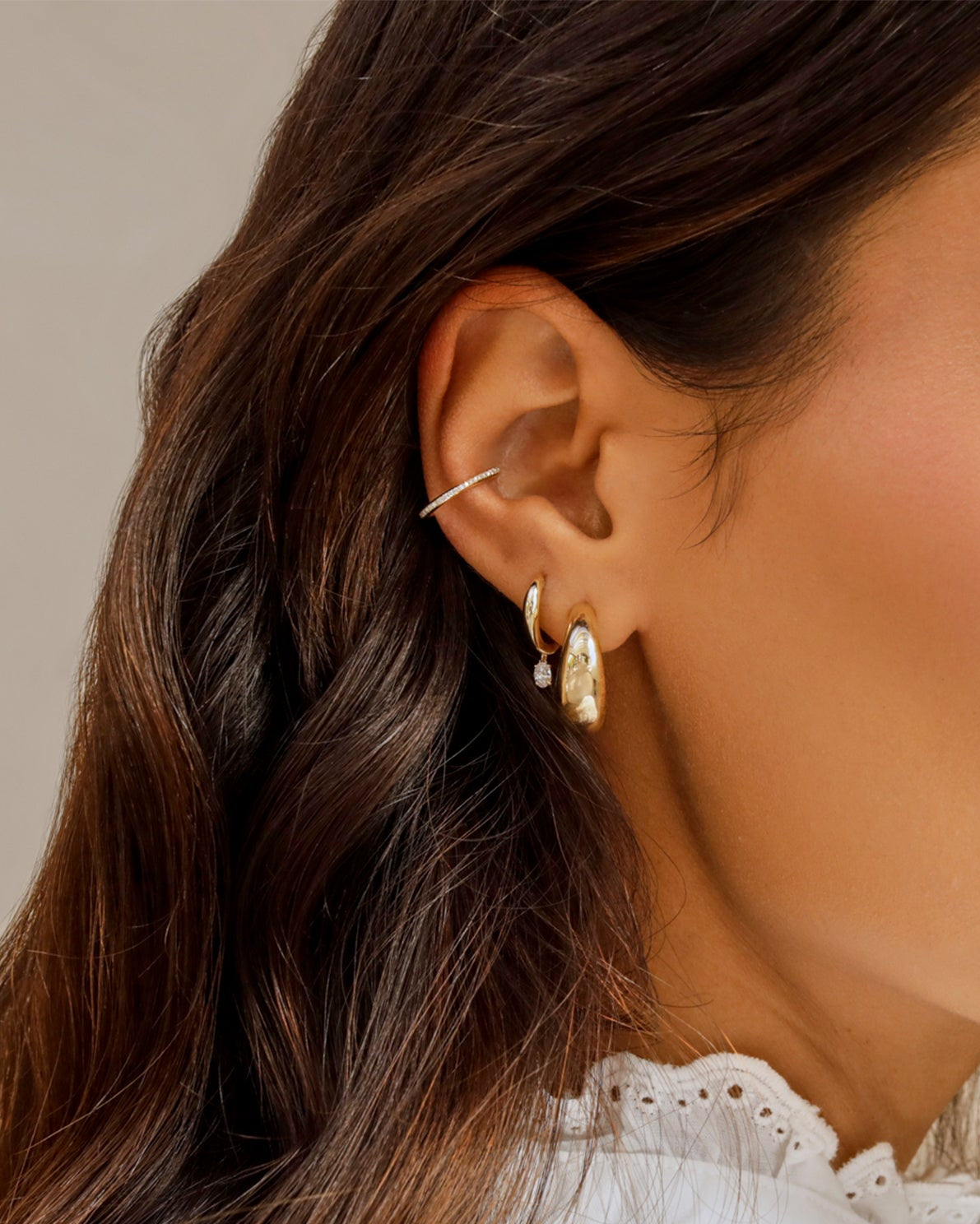 Gold Jumbo Dome Hoop Earrings in 14k yellow gold styled on ear lobe of model