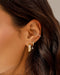 Diamond Oval Drop Gold Dome Huggie Earring in 14k yellow gold styled on second earring hole of model