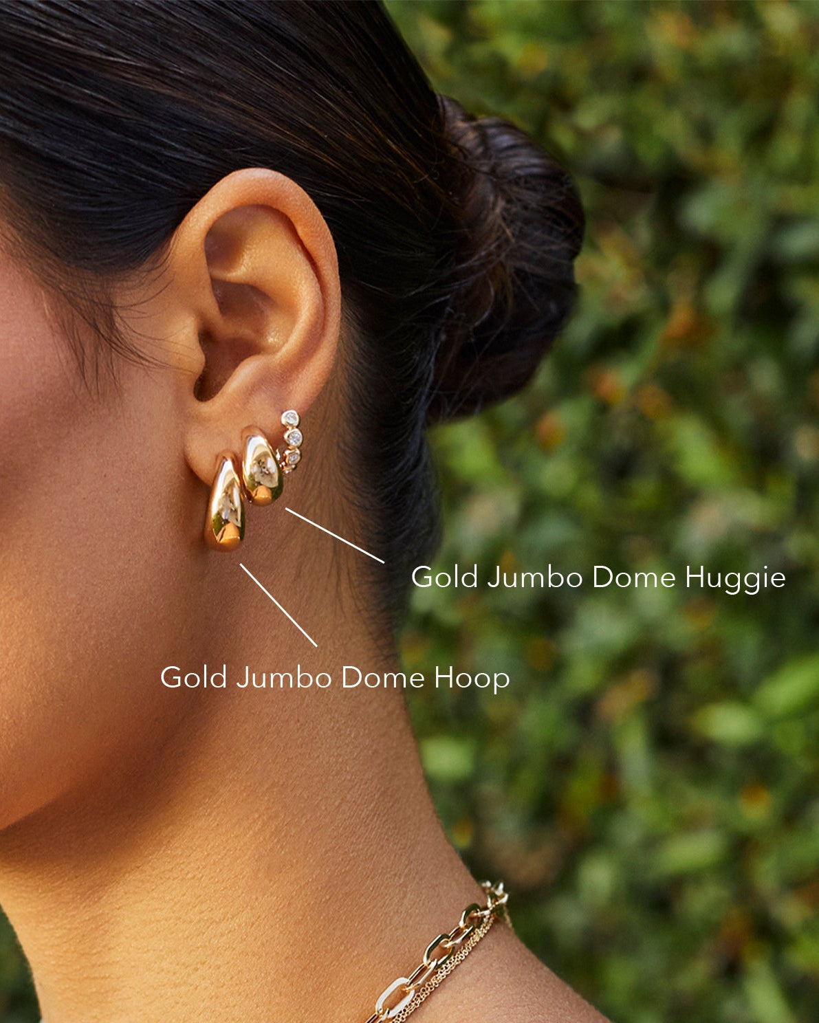 Gold Jumbo Dome Hoop Earrings in 14k yellow gold styled on ear lobe of model next to gold jumbo dome hugige earring and diamond pillow huggie earring