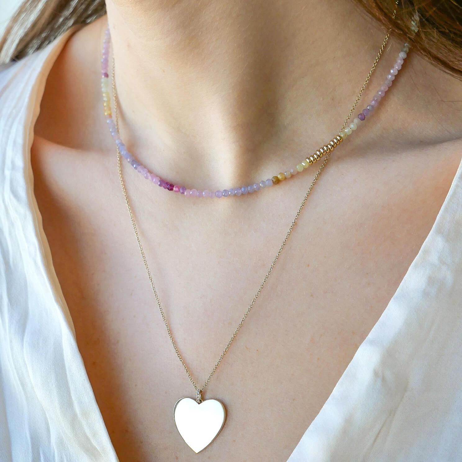 Ombré Sapphire Birthstone Bead Necklace in 14k yellow gold styled on neck of model with gold heart necklace