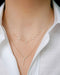 Multi Diamond Cluster Necklace in 14k yellow gold styled on neck of model with diamond waterfall necklace with model in white blouse