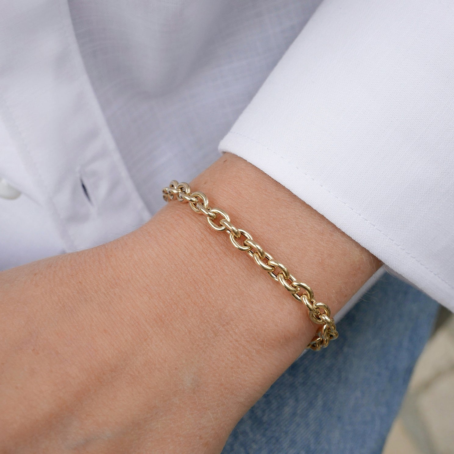 Sienna Chain Bracelet in 14k yellow gold styled on wrist of model in white blouse