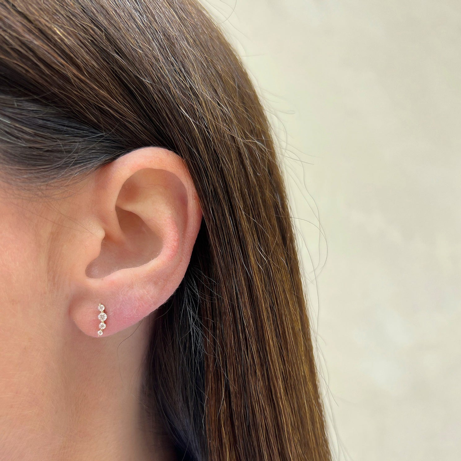 Prong Set Diamond Arc Stud Earring styled on ear lobe of model