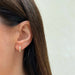 Diamond Twist Huggie Earring in 14k yellow gold styled on ear of model