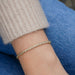 Diamond Twist Bracelet in 14k yellow gold styled on wrist of model with sweater sleeve