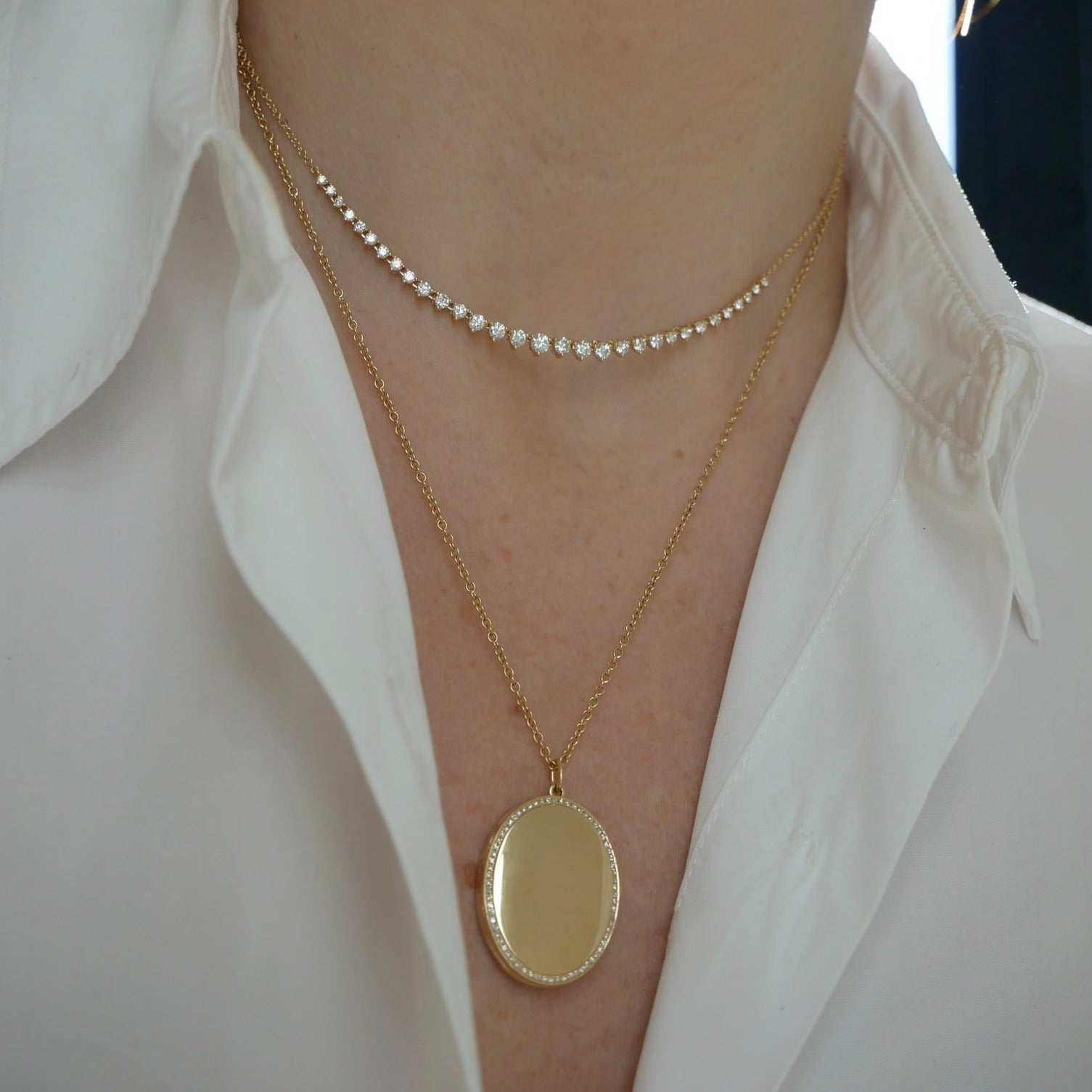 Gold and Diamond Oval Locket Necklace styled on neck of model with diamond necklace