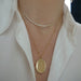 Gold and Diamond Oval Locket Necklace styled on neck of model with diamond necklace