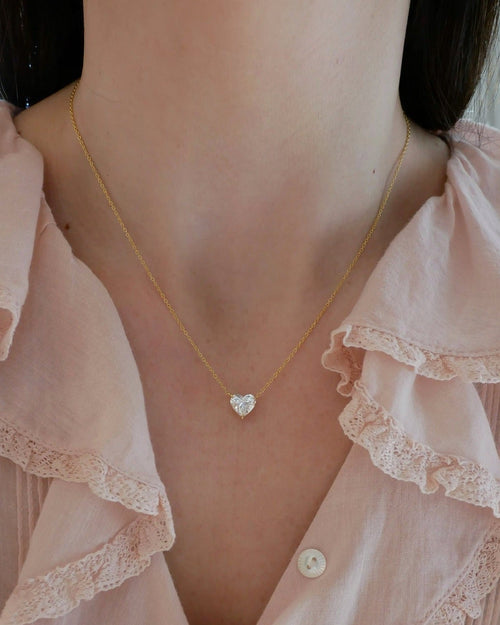 Diamond Heart Solitaire Necklace with 2 carat diamond with yellow gold chain styled on neck of model in pink blouse