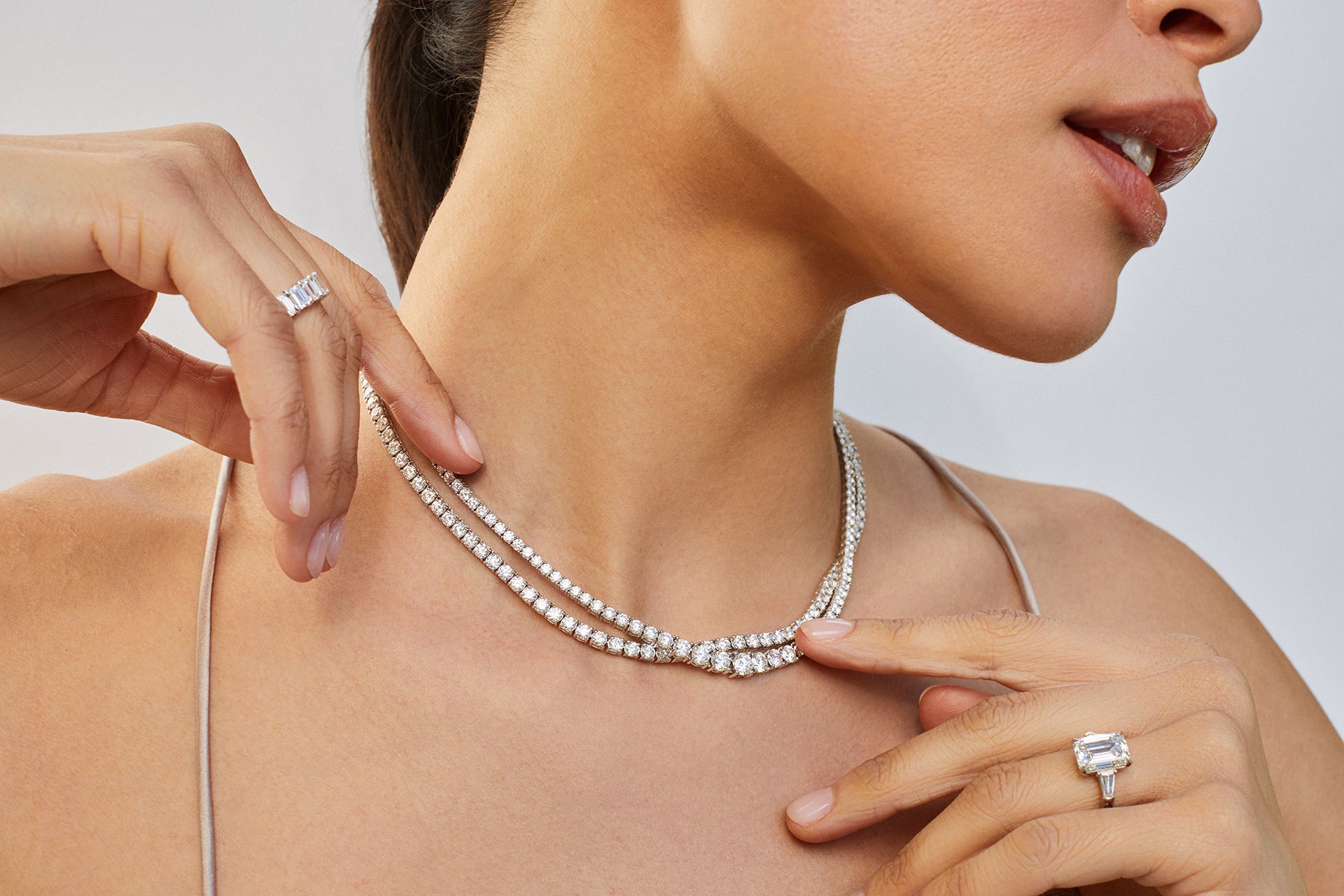 EF Collection diamond tennis necklaces styled on neck of model and diamond engagement ring styled on ring finger of model