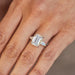 The Lauren Engagement Ring with emerald cut center stone and emerald cut stones on either side with platinum band styled on ring finger of model