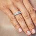Emerald Cut Diamond Eternity Band in platinum setting styled on ring finger of model