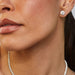 Round Diamond Solitaire Stud Earrings in two carat diamond styled on ear of model and diamond tennis necklace styled on neck of model