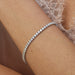Diamond Tennis Bracelet in 18k white gold with 6 carat diamonds styled on wrist of model