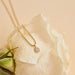 Full Cut Diamond Teardrop Necklace in 14k yellow gold on top of white rose