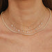 Diamond & White Quartz Ultimate Teardrop Necklace styled on neck of model with two gold and diamond necklaces