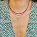 Full Cut Diamond Teardrop Lariat Necklace in 14k yellow gold styled on neck of model with gold and diamond necklace and two beaded necklaces. Model in green and white top