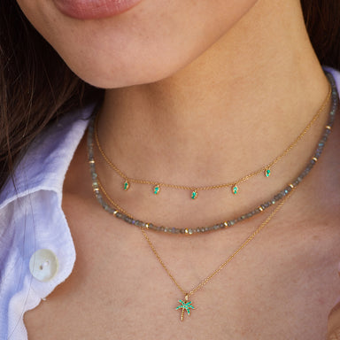 Emerald 5 Teardrop Choker Necklace in 14k yellow gold styled on neck of model with emerald palm tree necklace and beaded necklace