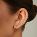 Baby Solitaire Diamond Stud Earring in 14k yellow gold styled on ear of model with four diamond earrings